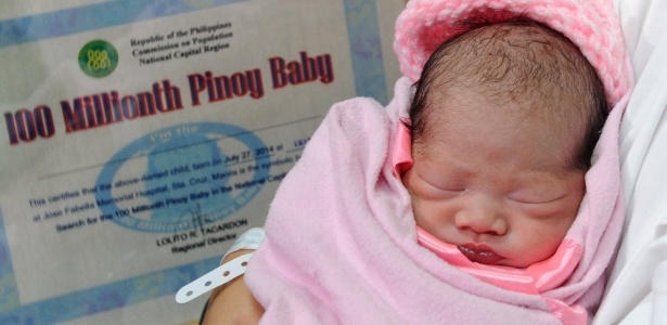 A recém-nascida Jennalyn Sentino dorme enquanto é apresentada como o "bebê número 100 milhões" - AFP