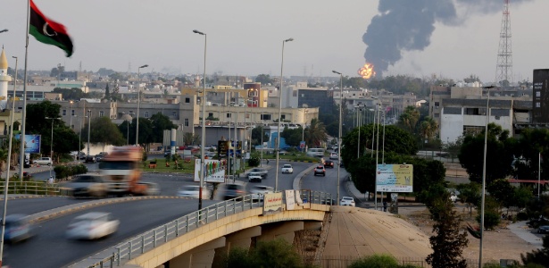 Coluna de fumaça emana do local de ataque a um armazém de combustível em Trípoli - Efe