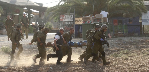 Soldados israelenses carregam colega ferido em conflito - Reuters
