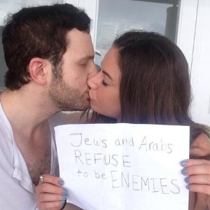 Sulome Anderson, jornalista americana de origem libanesa, beija seu namorado, israelense, e segura uma folha de papel em que está escrito: "Judeus e árabes se negam a ser inimigos". A foto, publicada no Twitter, deu origem a uma campanha nas redes sociais - Sulome Anderson/Twitter/Divulgação