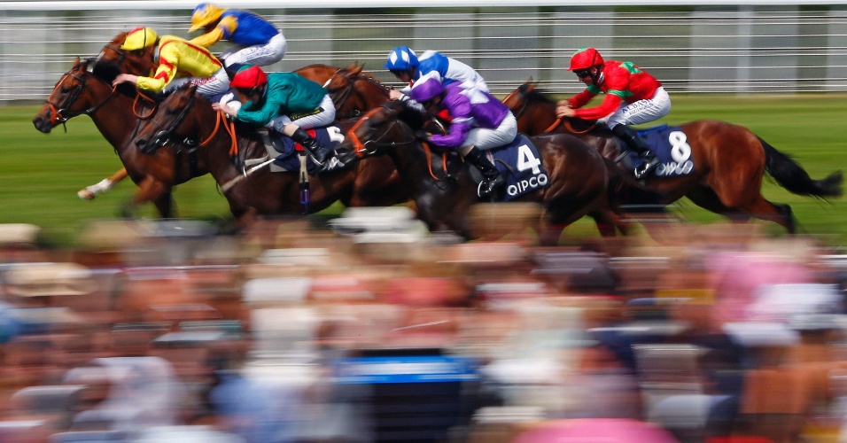 31.jul.2014 - Joqueis em suas montarias cruzam a linha de chegada da corrida de cavalos Qatar Bloodstock Richmond no hipódromo em Goodwood, na Inglaterra, durante um dos eventos de maior prestígio do calendário de corridas do Reino Unido