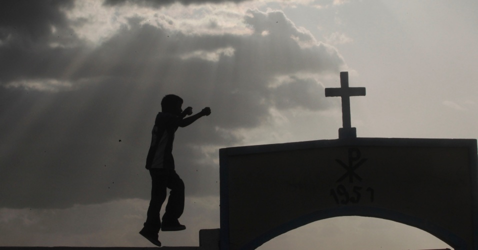 1º.ago.2014 - Menino salta perto de cruz durante a festa do padroeiro de Manágua, Santo Domingo de Guzmán, em Manágua, na Nicarágua