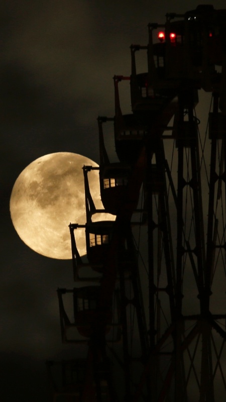10.ago.2014 - Superlua aparece por de trás de uma roda-gigante em Tóquio, no Japão. O fenômeno ocorre quando a Lua cheia coincide com o momento em que ela está mais próxima da Terra. Esta é a maior superlua do ano - Toru Hanai/Reuters