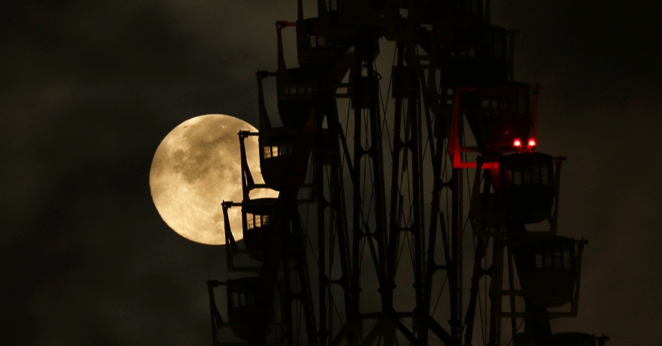 10.ago.2014 - Superlua aparece por de trás de uma roda-gigante em Tóquio, no Japão. O fenômeno ocorre quando a Lua cheia coincide com o momento em que ela está mais próxima da Terra. Esta é a maior superlua do ano