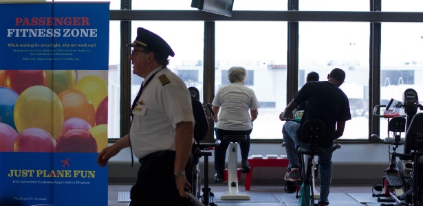 Enquanto aguardam embarque, passageiros se exercitam no Aeroporto Internacional da Filadélfia (EUA) - Jessica Kourkounis / The New York Times