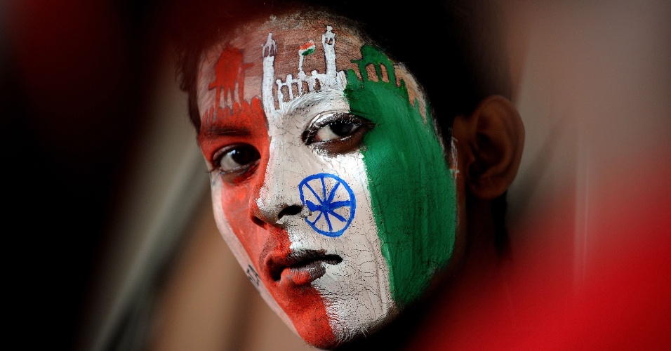 14.ago.2014 - Com o rosto pintado nas cores da bandeira nacional indiana, um aluno se prepara para participar de manifestação na véspera do Dia da Independência em Mumbai, na Índia
