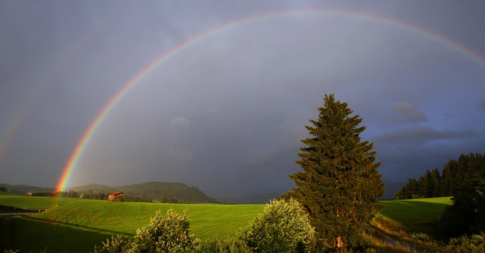 14.ago.2014 - Um arco-íris se estende ao longo do planalto alpino perto de Hopfereau, na Alemanha
