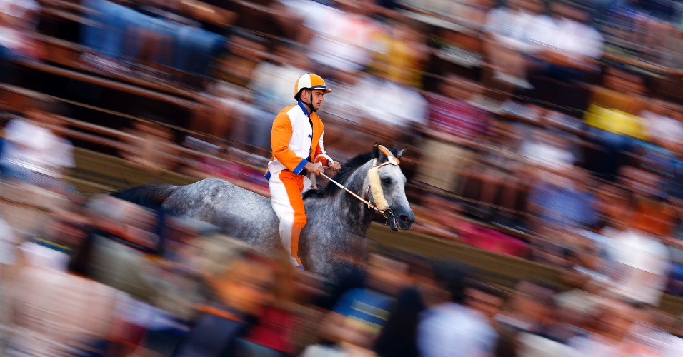 15.ago.2014 - Jóquei "Leocorno" monta cavalo durante o último dia de treinos para a corrida de Palio,  em Siena, na Itália