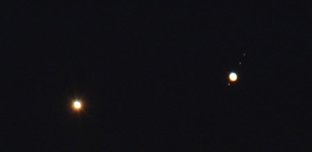 Vênus (à esq.) e Júpiter (dir.) parecem muito próximos nesta rara conjunção dos planetas, que são vistos aqui sobre as pontes Hell Gate e Robert F. Kennedy na manhã desta segunda-feira (18) em Nova York - Stan Honda/AFP