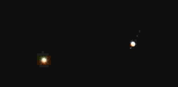 Vênus (à esq.) e Júpiter (dir.) parecem muito próximos nesta rara conjunção dos planetas, que são vistos aqui sobre as pontes Hell Gate e Robert F. Kennedy na manhã desta segunda-feira (18) em Nova York - Stan Honda/AFP