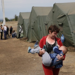 18.ago.2041 - Mulher carrega bebê em acampamento de refugiados em Izvarino, a 10 km da fronteira entre Rússia e Ucrânia - Yuri Kochetkov/EFE 