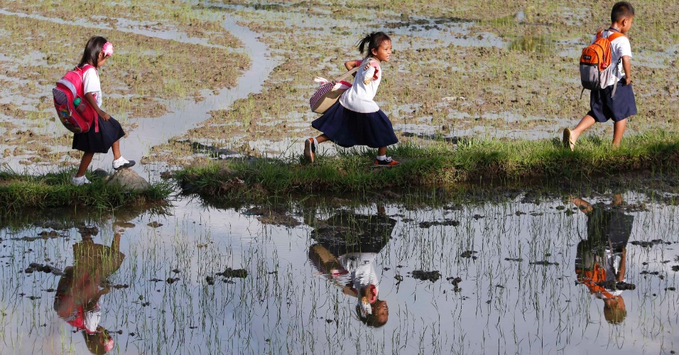 19.ago.2014 - Alunos de escola primária percorrem arrozais a caminho de casa, depois de assistir a aulas de Mogpog, em Marinduque,nas Filipinas