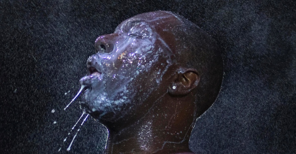20.ago.2014 - Homem é encharcado por uma névoa de leite pulverizado após ser atingido por gás lacrimogêneo das forças de segurança dos Estados Unidos, em uma manifestação contra o assassinato do adolescente negro Michael Brown em Ferguson, no Missouri