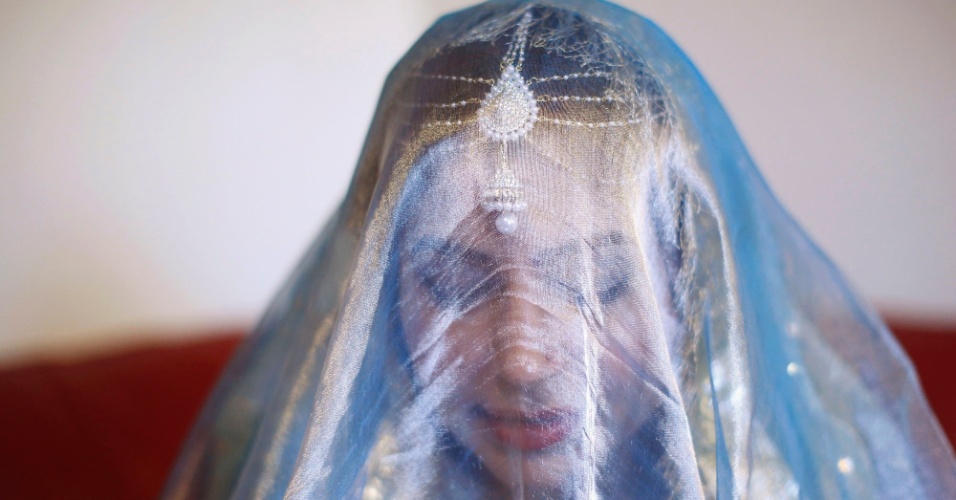 21.ago.2014 - Mulher paquistanesa muçulmana usa um véu tradicional na bênção do casamento realizado em casa, no bairro de Walthamstow, em Londres, no Reino Unido