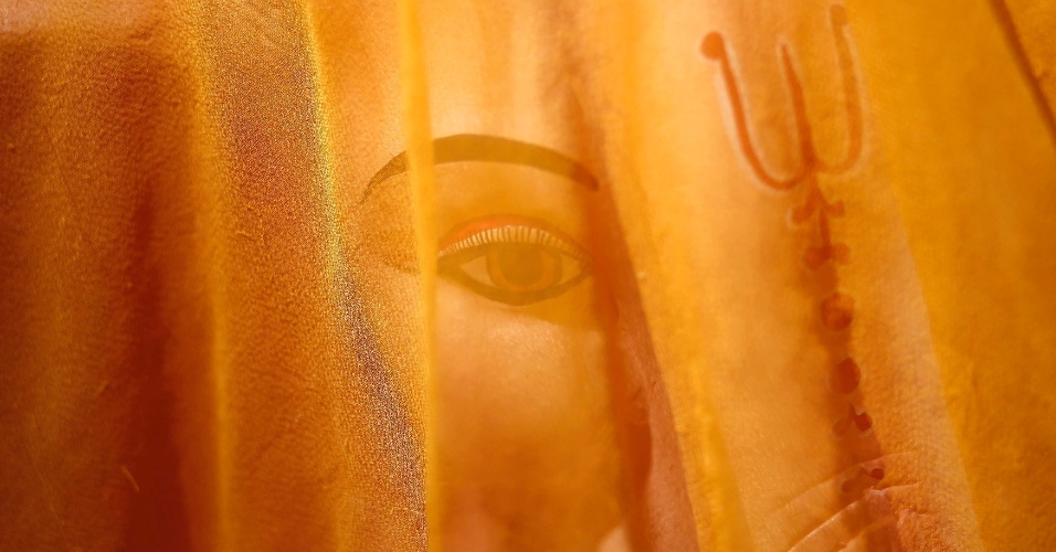 25.ago.2014 - Pano cobre imagem de deus hindu Ganesh (divindade da prosperidade) em uma oficina de beira de estrada em Nova Déli, na Índia