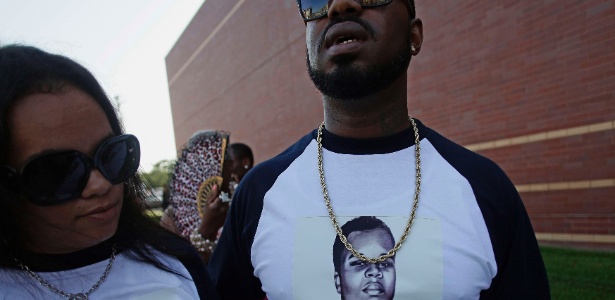 Grupo vestindo camisetas com fotos de Michael Brown aguardam sua vez em uma fila para participar do funeral do jovem negro que foi morto durante uma ação policial na cidade norte-americana de Ferguson, no Estado de Missouri, na semana passada. A morte de Brown causou revolta na comunidade negra da região e resultou em diversos protestos e prisões - Joshua Lott/Reuters