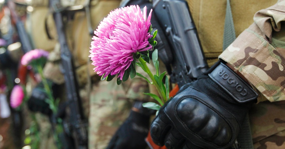26.ago.2014 - Voluntário do batalhão especial "Sich" do Ministério do Interior ucraniano segura uma flor durante a cerimônia de juramento e lealdade a seu país, em Kiev, na Ucrânia