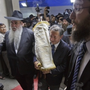 George Rohr (ao centro) segura a Torá durante a cerimônia de reabertura do centro judaico do Chabad-Lubavitch, em Mumbai (Índia) - Kuni Takahashi/The New York Times