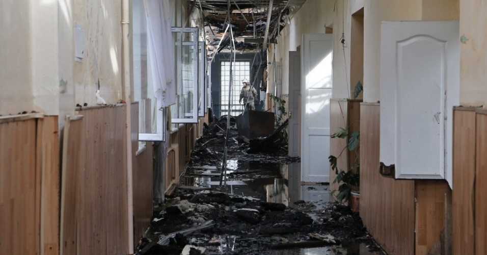 28.ago.2014 - Bombeiro observa corredor de escola atingida por incêndio em Donetsk, no leste da Ucrânia. Rebeldes pró-Rússia, que controlam a cidade, afirmam que a escola foi atingida por bombardeio de forças ucranianas