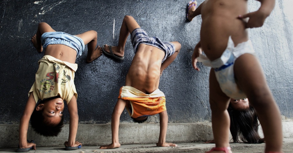 28.ago.2014 - Crianças mostram suas habilidades acrobáticas em uma passagem subterrânea em Manila, na Filipinas