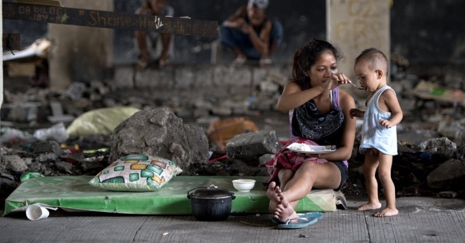 28.ago.2014 - Mãe alimenta bebê em uma passagem subterrânea em Manila, nesta quinta-feira (28). A economia das Filipinas subiu para 6,4% no segundo trimestre e recuperou o status de uma das mais fortes na Ásia