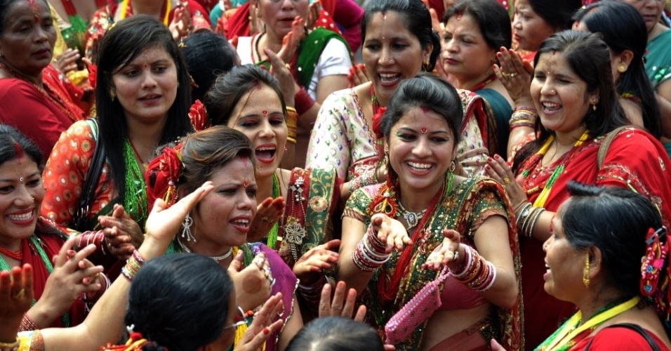 28.ago.2014 - Mulheres hindus nepalesas dançam após homenagens ao deus Shiva, na celebração do Teej no templo de Pashupatinath, em Katmandu. No festival, por três dias, mulheres casadas jejuam durante o dia e oram por uma vida longa para seus maridos, enquanto mulheres solteiras fazem pedidos por maridos bonitos e por uma futura vida conjugal feliz