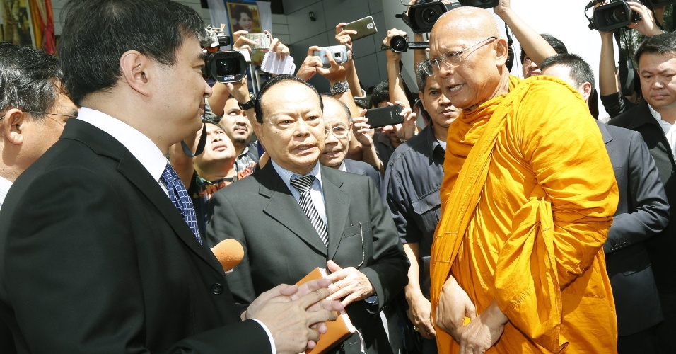 28.ago.2014 - O ex-primeiro-ministro da Tailândia Abhisit Vejjajiva (à esquerda) conversa com o monge budista Suthep Thaugsuban (à direita), que foi seu vice, após ambos saírem de tribunal penal em Bancoc. O tribunal tailandês retirou as acusações de assassinato e abuso de poder contra os dois políticos pela repressão contra os protestos da oposição em 2010, que deixou cerca de 90 mortos e quase dois mil feridos