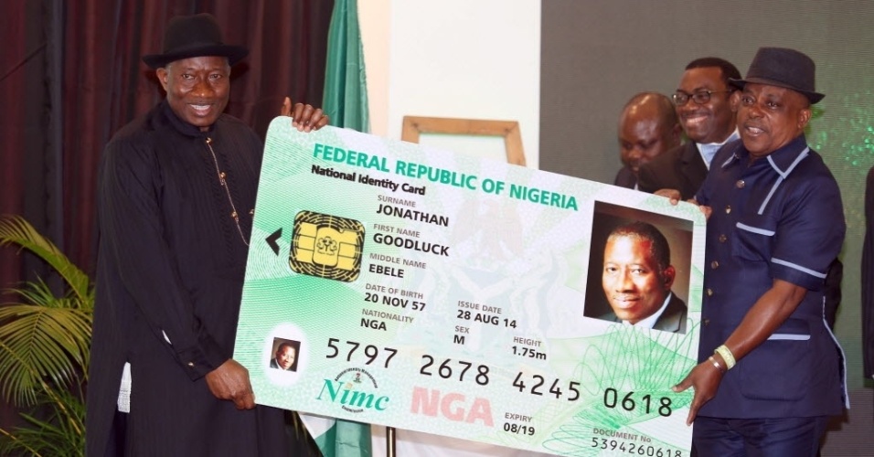 28.ago.2014 - O presidente nigeriano, Goodluck Jonathan (à esquerda), exibe uma réplica de sua carteira de identidade eletrônica junto com o presidente do conselho da Comissão Nacional de Gerenciamento de Identidade (NIMC), Uche Secoundus (à direita), durante o lançamento dos cartões em Abuja, nesta quinta-feira (28). Esta é a primeira fase de um programa que visa o aumento da inclusão financeira na Nigéria