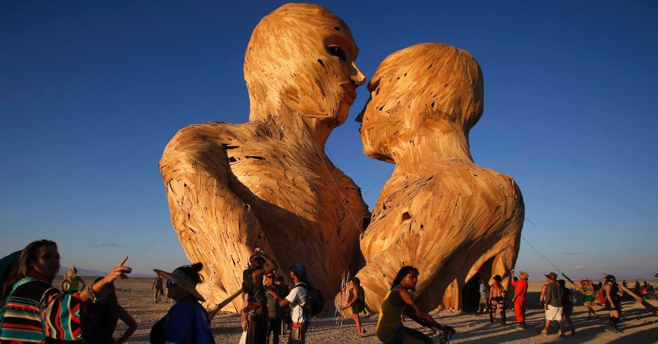 28.ago.2014 - Jovens reúnem-se em torno da instalação "Embrace", durante o festival de arte e música Burning Man 2014 "Caravansary", no deserto de Black Rock de Nevada, nos EUA