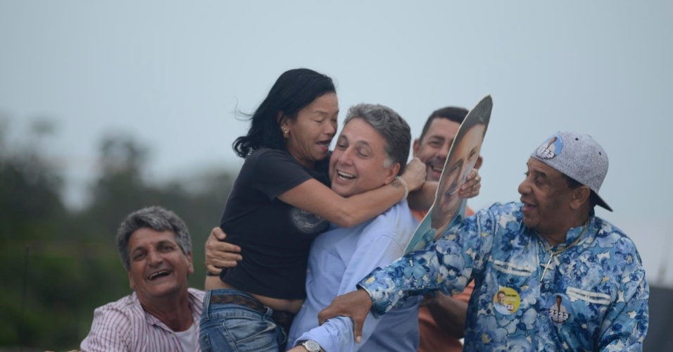 30.ago.2014 - O candidato ao governo do Rio Anthony Garotinho (PR) é abraçado por eleitora durante carreata em Sepetiba, zona Oeste do Rio de Janeiro