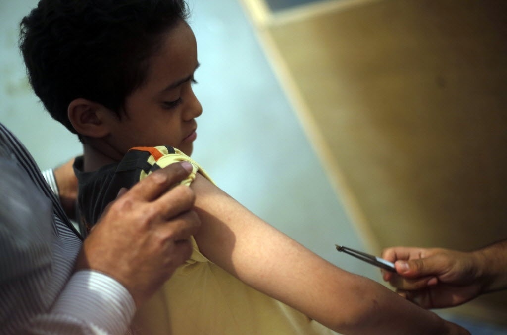 1º.set.2014 - Haj Saied Al Sayeeh aproxima uma abelha de um menino que sofre de diabetes, em seu centro médico no Cairo (Egito). Al Sayeeh  acredita que o veneno das abelhas tem propriedades especiais, que, quando utilizadas em partes específicas do corpo, pode curar doenças como problemas renais, apendicite e até câncer - Amr Abdallah Dalsh/Reuters