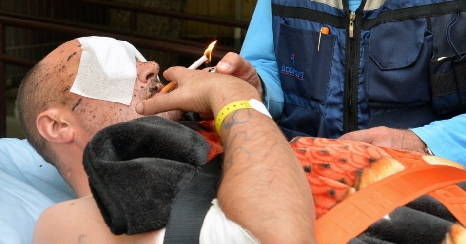 2.set.2014 - Um soldado ucraniano ferido acende um cigarro antes de ser levado por uma ambulância ao Hospital Militar de Kiev. O homem será transferido para a Alemanha, que concordou em tratar 20 militares feridos em confrontos com rebeldes pró-Rússia