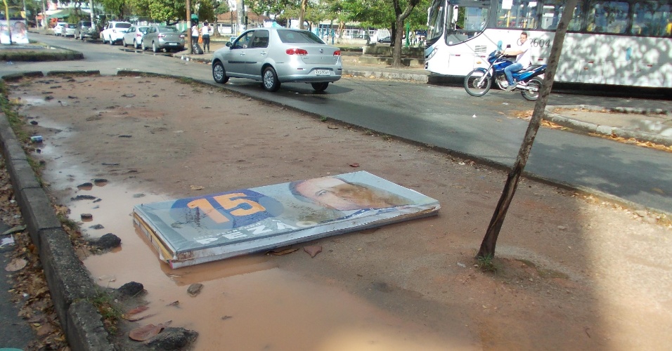 4.set.2014 - Placa do candidato ao governo do Estado do Rio de Janeiro pelo PMDB, Luiz Fernando Pezão, fica jogada no chão de praça na Vila Valqueire, após chuva atingir a zona oeste da cidade