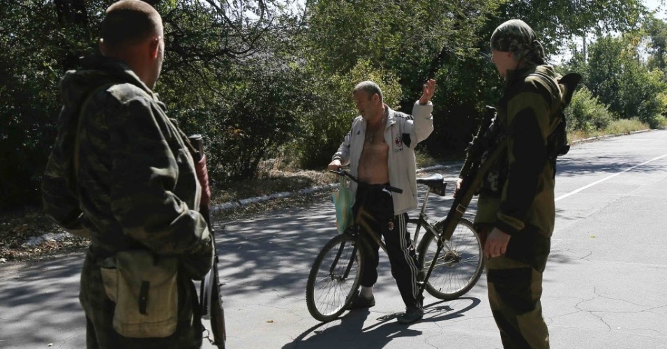 6.set.2014 - Separatistas pró-russos conversam com um morador local em um ponto de verificação na periferia de Donetsk, na Ucrânia, um dia depois de o governo do país e os rebeldes assinarem um acordo de cessar-fogo
