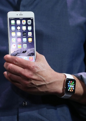Tim Cook, diretor-executivo da Apple, segura um iPhone 6 durante apresentação do smartphone - Justin Sullivan/Getty Images/AFP