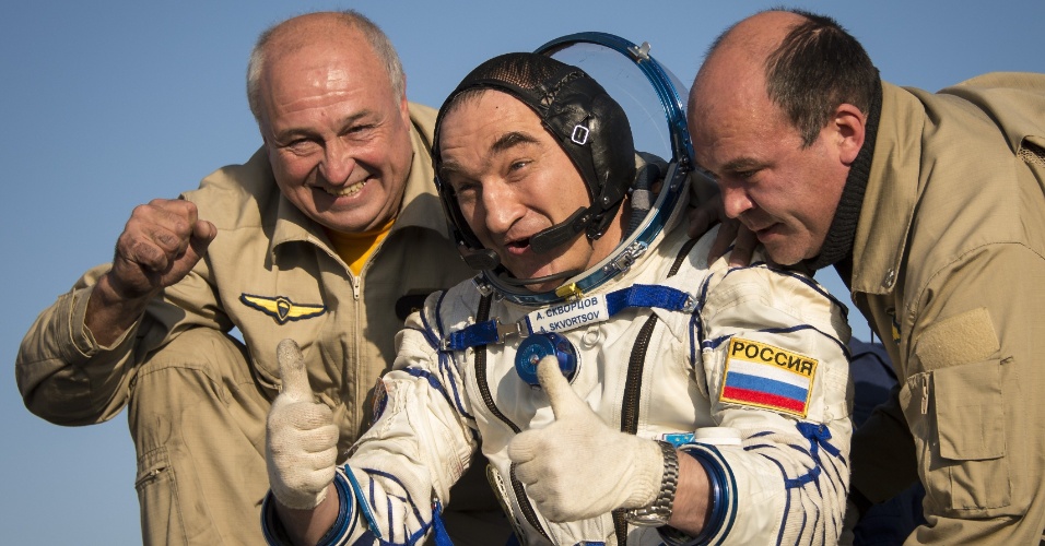 11.set.2014 - Alexander Skvortsov, engenheiro de voo da Agência Espacial Federal Russa, acena enquanto recebe ajuda para sair da capsula Soyuz poucos minutos após ela aterrissar, em uma área remota perto da cidade de Zhezkazgan, no Cazaquistão. Skvortsov, outro cosmonauta e um astronauta norte-americano passaram mais de cinco meses a bordo da Estação Espacial Internacional, onde atuaram como tripulantes das expedições 39 e 40