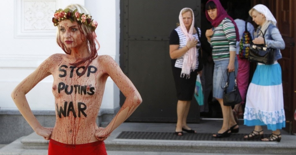 11.set.2014 - Religiosas observam ativista do Femen durante protesto em frente ao mosteiro de Pechersk Lavra em Kiev, na Ucrânia. A manifestação foi contra a ofensiva russa no país