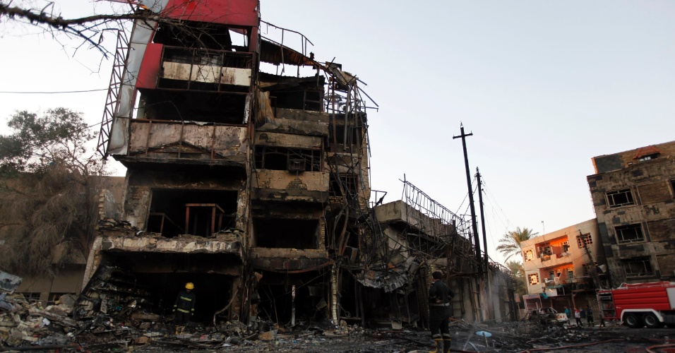 11.set.2014 - Bombeiros inspecionam local de ataque com carro-bomba em Bagdá