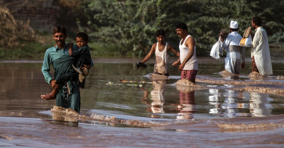 11.set.2014 - Paquistaneses percorrem campo inundado após fortes chuvas em Jhang, Província de Punjab. As chuvas de monções, que nesta estação já mataram cerca de 450 pessoas na Índia e no Paquistão, começaram a perder força na quarta-feira, dando às equipes de resgate a chance de evacuar milhares de moradores presos na região