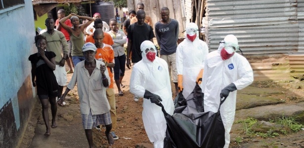 Profissionais da saúde removem o corpo de Prince Nyentee, um homem de 29 anos de idade que teria morrido por causa do vírus ebola em Monróvia, na Libéria  - James Giahyue/Reuters
