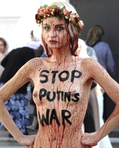11.set.2014 - Ativista do grupo Femen se banha com sangue falso durante protesto em Kiev, na Ucrânia, contra a intervenção da Rússia no país. Em seu corpo está escrito ?Pare a guerra de Putin?, fazendo menção ao presidente russo, Vladimir Putin