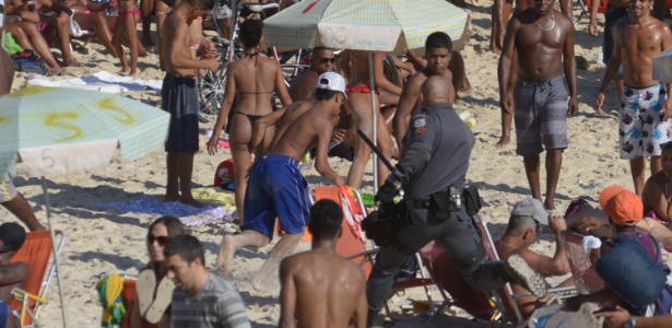 Policial persegue suspeito na praia do Arpoador, em Ipanema, na zona sul do Rio de Janeiro, na tarde deste domingo (14) - Erbs Jr./ Frame