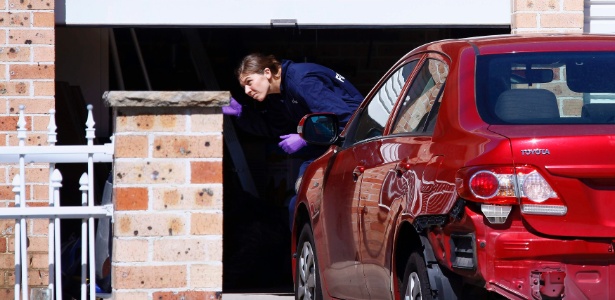 Agente da Polícia Federal australiana investiga casa em subúrbio de Sydney durante série de batidas para evitar "potenciais ataques" terroristas