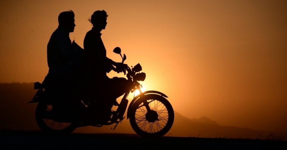 20.set.2014 - Afegãos andam de moto enquanto o sol se põe aos arredores de Mazar-i-Sharif, neste sábado (20)