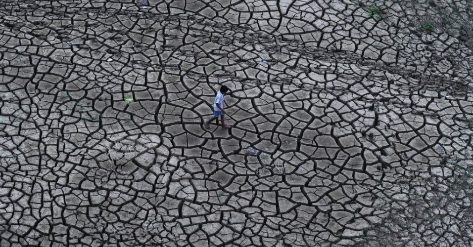 20.set.2014 - Indiano caminha por lama seca nas margens de um rio que recuou depois das chuvas de monções, neste sábado (20), em Allahabad