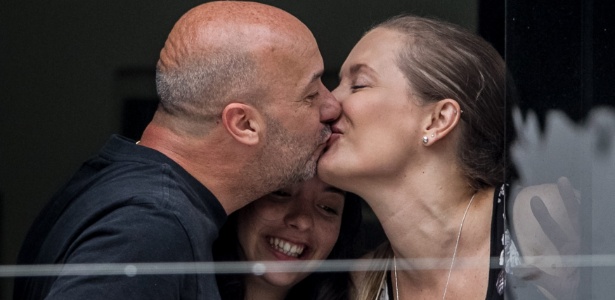 Ivan Simonovis beija sua mulher, Bony (dir), ao lado da filha, Ivana (centro), na janela de sua casa, em Caracas; o oposicionista venezuelano está em prisão domiciliar