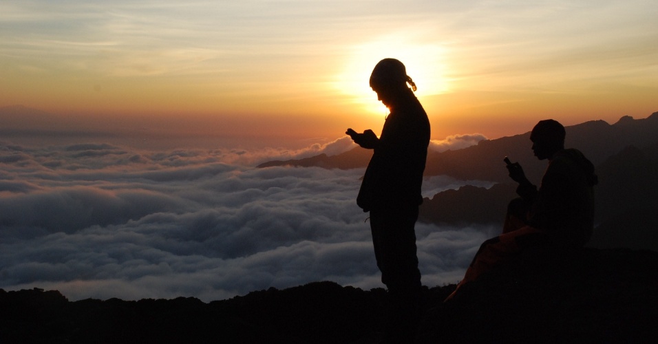 22.set.2014 - Turistas tentam conseguir sinal para o celular durante sua subida ao topo do monte Kilimanjaro, na Tanzânia