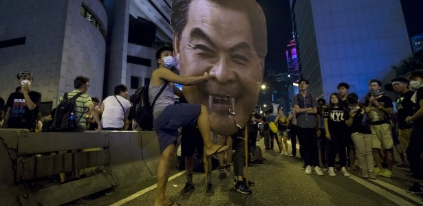 Um manifestante atinge um recorte com o rosto do chefe do executivo de Hong Kong, Leung Chun-ying, durante protesto próximo a escritórios do governo no distrito financeiro central de Admiralty, em Hong Kong (China) - Tyrone Siu/Reuters