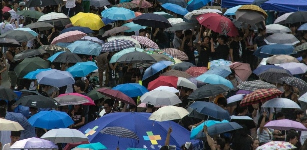 Ativistas pró-democracia abrem guarda-chuvas durante ato em frente à sede do governo de Hong Kong, na China. Os protestos em Hong Kong foram apelidados de "Revolução dos guarda-chuvas", pois os manifestantes usam o objeto como escudo para se defender de ataques da polícia, que usa gás-lacrimogêneo e spray de pimenta - Annabel Symington/ AFP