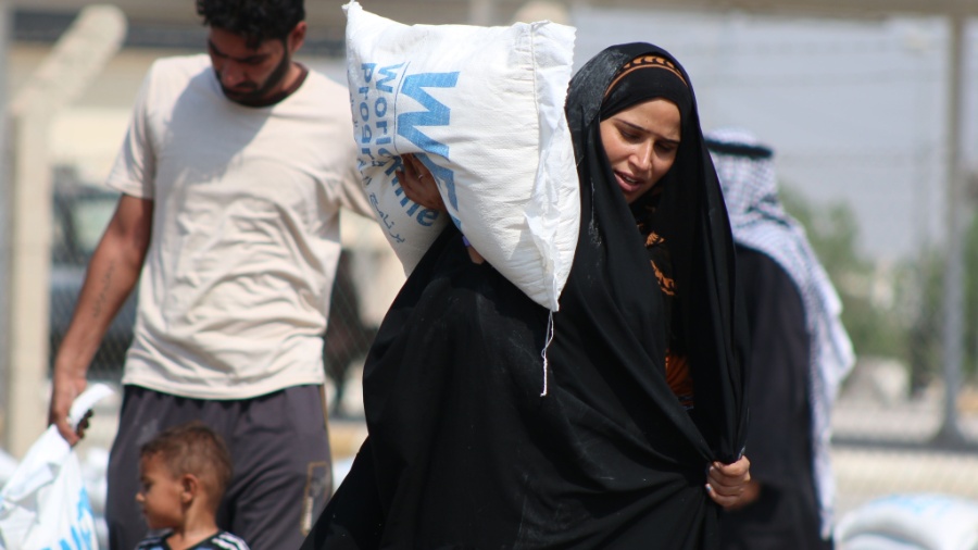 Refugiados iraquianos, que deixaram as suas casas após uma ofensiva liderada pelo Estado Islâmico, recebem sacos de comida doados pelo Programa Alimentar Mundial na cidade de Basra, no Iraque, em 2014  - Mohammed Ali Haidar/AFP